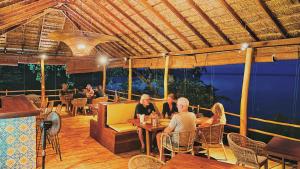 a group of people sitting at a restaurant at Oruwa Boutique Villa in Pottuvil