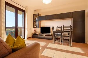 sala de estar con cocina con mesa y TV en Terrazza Catabbio, en Catabbio