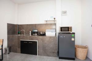 une petite cuisine avec un évier et un réfrigérateur dans l'établissement comfortable BAMBOO houses, à Ban Thalat Choeng Thale