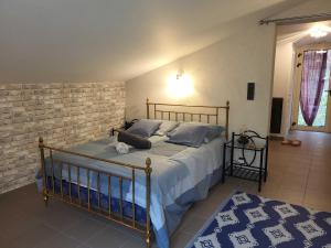 a bedroom with a bed and a brick wall at Gite du grand braquet in Puget-Théniers