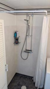 una ducha en un baño con cortina de ducha en Boats stay play lake cabin, en Broby