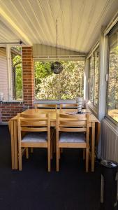 una mesa de madera y sillas en un porche cubierto en Boats stay play lake cabin, en Broby