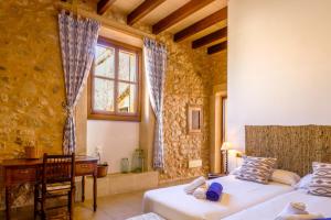 a bedroom with two beds and a desk and a window at Son Pons in Llucmajor