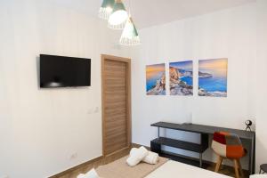 a bedroom with a bed and a desk and a tv at Adagos in Palermo