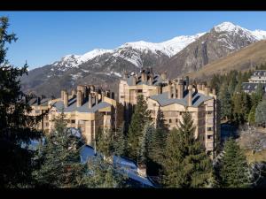 a large building in front of a mountain with snow at Aubars de Alma de Nieve in Naut Aran
