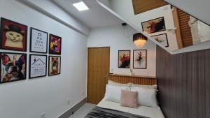 a bedroom with a bed and some pictures on the wall at Stúdio 7 climatizado, centro-terreo-privativo in Domingos Martins