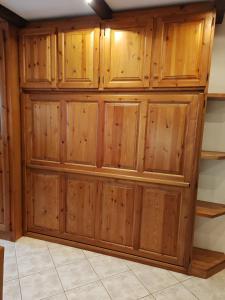 a wooden closet with wooden doors on a wall at La Baita del Sagittario in Prato Nevoso