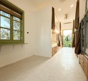 a hallway with white walls and a large window at White Elephant Hostel in Luang Prabang