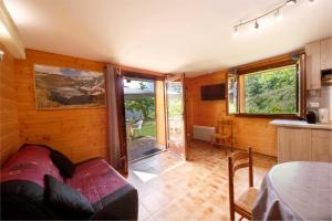 un salon avec un canapé et une cuisine dans l'établissement Les jasmins, à Saint-Étienne-de-Tinée