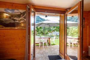 une porte ouverte sur une terrasse avec un parasol dans l'établissement Les jasmins, à Saint-Étienne-de-Tinée