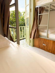琅勃拉邦White Elephant Hostel的一间带双层床的卧室和一个阳台