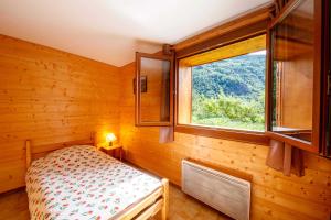 une chambre avec un lit et une fenêtre dans l'établissement Les jasmins, à Saint-Étienne-de-Tinée