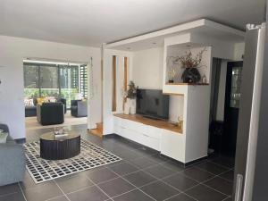 a living room with a tv and a couch at Villa spacieuse avec piscine à Saint-François 196 m² in Saint-François