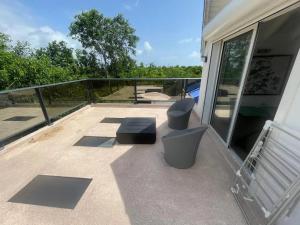 a balcony with two chairs and a bench on it at Villa spacieuse avec piscine à Saint-François 196 m² in Saint-François