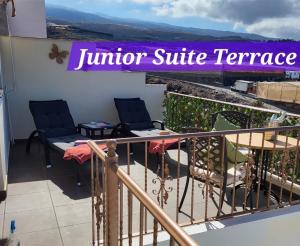 Ein Balkon mit zwei Stühlen und einem Schild mit der Aufschrift „Terrasse der Junior-Suite“. in der Unterkunft Casa Mariposa in Playa de San Juan
