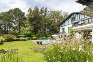 um quintal com uma piscina e uma casa em Golfetmer em Saint-Jean-de-Luz