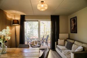 un salon avec un canapé et une table dans l'établissement Holiday home with sauna on Panjevaart - VP100, à Hoeven