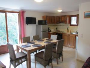a kitchen with a wooden table and chairs in a room at La grange neuve in Bairols