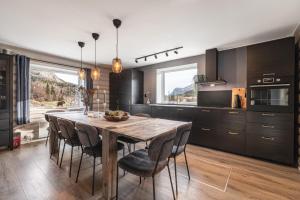 eine Küche mit einem Holztisch und Stühlen in der Unterkunft Spacious Hemsedal home with ski slope view in Kyrkjebøen