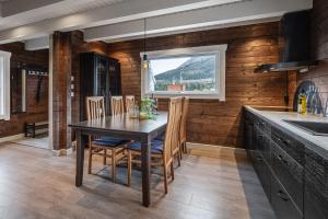 eine Küche mit Tisch und Stühlen und einem Fenster in der Unterkunft Unique 'Stabbur' in Hemsedal, view to skislopes in Kyrkjebøen