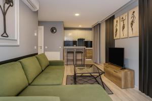a living room with a green couch and a television at On4 Rooms & Suites in Istanbul