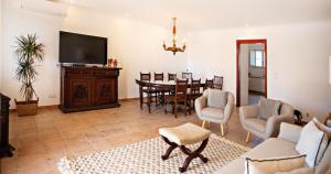 een woonkamer met een televisie en een eetkamer bij Ria Endless South - Barroca Village - Sítio da Fortaleza in Tavira