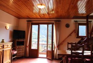 a living room with a table and a sliding glass door at Chez memene in Valdeblore