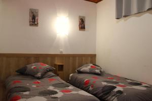 a bedroom with two beds and a light on the wall at Chez memene in Valdeblore