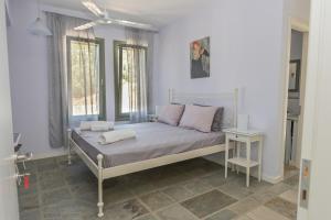 ein Schlafzimmer mit einem Bett und einem Fenster in der Unterkunft Villa Santa Friday in Antikes Epidauros + 64 Fotos