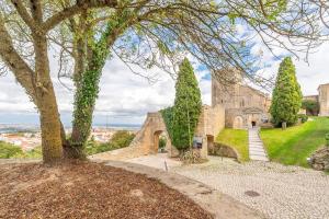 an old stone building on a hill with trees at Guest Ready - Charming Retreat in Palmela in Palmela