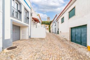 a cobblestone street in a town with white buildings at Guest Ready - Charming Retreat in Palmela in Palmela