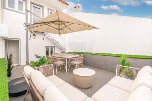 a patio with a table and an umbrella at Guest Ready - Charming Retreat in Palmela in Palmela