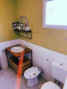 a bathroom with a sink and a toilet and a window at El Ventanal in Las Rabonas