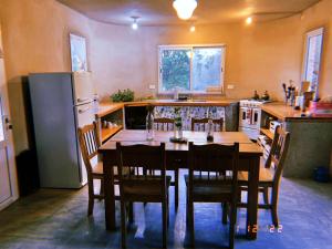 a kitchen with a table with chairs and a refrigerator at El Ventanal in Las Rabonas +4 photos