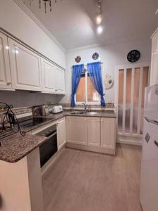 テルアビブにあるWelcome to your upscale coastal escape!のキッチン(白いキャビネット、青いカーテン付) +3枚の写真