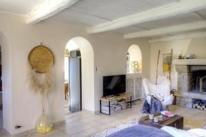 a living room with a fireplace and a tv at L'aire in Lantosque