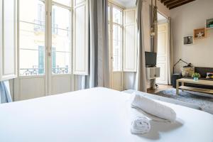 a bedroom with a white bed and large windows at NOMADIA en LARIOS STREET in Málaga