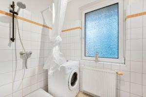 ein Bad mit einer Waschmaschine und einem Fenster in der Unterkunft Apartment in Celle for Business Traveler in Celle + 8 Fotos