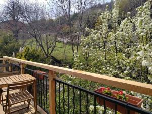 a balcony with a table and a bench and flowers at La sittelle in Belvédère
