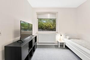 ein Schlafzimmer mit einer schwarzen Kommode, einem Bett und einem Fenster in der Unterkunft Apartment in Celle for Business Traveler in Celle