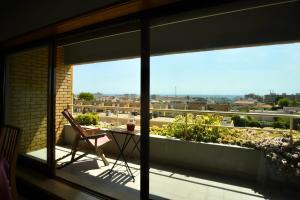 Un balcón con una mesa y vista a la ciudad. en sunset@leçadapalmeira, en Matosinhos
