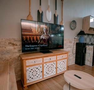 einen Flachbild-TV auf einem hölzernen Entertainment-Center in der Unterkunft Villa Soluna Lovina in Lovina + 13 Fotos