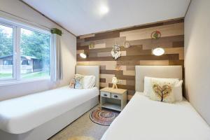 Dos camas en una habitación con ventana. en Lucky Lodge with Hot Tub, en York