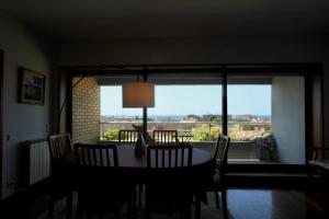 Una mesa de comedor con sillas y una gran ventana. en sunset@leçadapalmeira, en Matosinhos