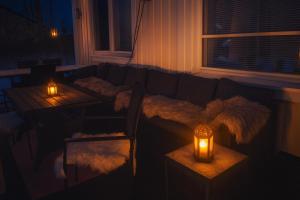 a living room with a couch and two tables with lights at Rovaniemi Riverside Family House near Santa Claus Village - Sauna & Aurora View in Rovaniemi