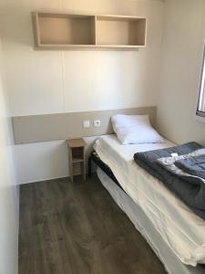 a small bedroom with a bed and a small table at MH518 3chambres et 1 sdb de 40m2 dans camping 4 étoiles in Saint-Julien-en-Born