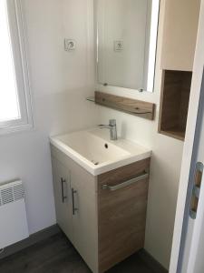 a bathroom with a sink and a mirror at MH518 3chambres et 1 sdb de 40m2 dans camping 4 étoiles in Saint-Julien-en-Born