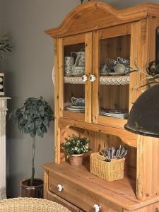 a wooden cabinet with dishes in it with a potted plant at Hildes Bett in Aschersleben +15 photos
