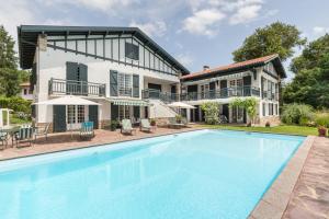 une image d'une piscine en face d'une maison dans l'établissement Golfetmer, à Saint-Jean-de-Luz