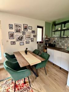 a dining room with a wooden table and green chairs at Apartment No 3 in Fulda